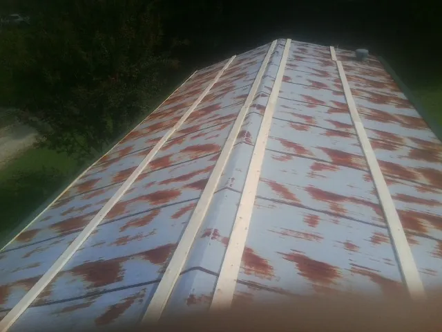 Rusted metal roof panels with new wood purlins before replacement — Storm Damage Roof Repair in Cavour by Roofing Brothers